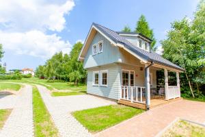 a small blue house with a driveway at Camping Pomona in Niechorze