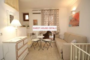 uma sala de estar com um sofá e uma mesa em Sweet House em Cefalù