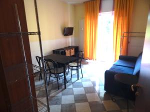a living room with a table and chairs and a couch at RESIDENCE HOTEL ISABELLA in Loano