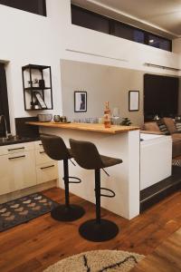 a kitchen with a counter and two bar stools at Stilvolles City-Loft mit privatem Whirlpool in Trier