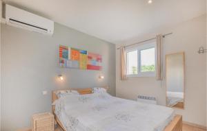 a white bedroom with a bed and a window at Cozy Home In Villelongue in Villelongue-de-la-Salanque +38 photos