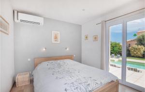 a bedroom with a bed and a large window at Cozy Home In Villelongue in Villelongue-de-la-Salanque