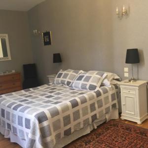 een slaapkamer met een bed met een blauwe en witte deken bij Comfortable Gite (2) in attractive Languedoc Village in Magalas