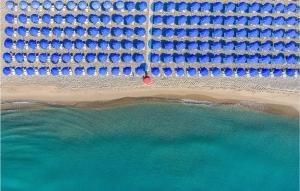 uma vista sobre uma praia com guarda-sóis azuis em Danaide Bilo em Scanzano mais 28 fotografias