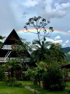 a rainbow in the sky over a house at Recanto Suíço in Lumiar