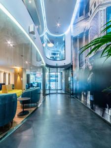 a lobby of a building with a hallway with blue chairs at Hotel Indigo Madrid - Gran Vía by IHG in Madrid
