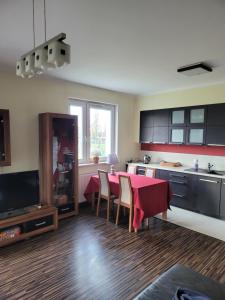 cocina con mesa y mantel rojo en Apartament Glinki, en Bydgoszcz