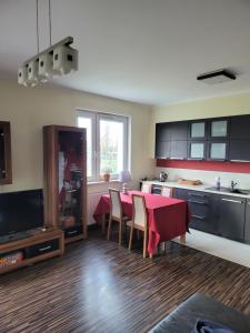 a kitchen with a table with a red table cloth at Apartament Glinki in Bydgoszcz