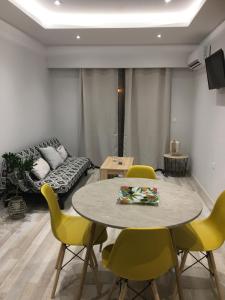 a living room with a table and chairs and a couch at RHODIAN TREASURE Spiridione apartment in Rhodes Town