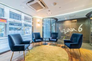 a waiting room with blue chairs and a rug at Hotel Indigo Madrid - Gran Vía by IHG in Madrid