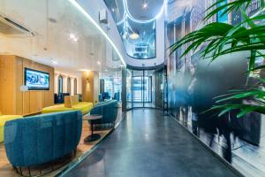 a lobby with blue chairs and plants in a building at Hotel Indigo Madrid - Gran Vía by IHG in Madrid