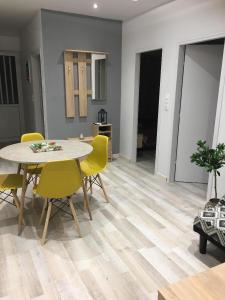 a dining room with a table and yellow chairs at RHODIAN TREASURE Spiridione apartment in Rhodes Town