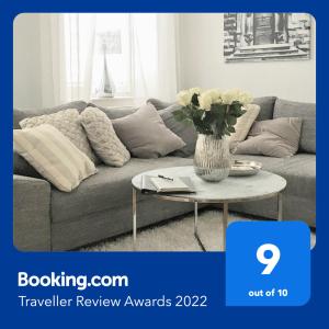 uma sala de estar com um sofá e uma mesa com um vaso de flores em KLASSIK Design-Luxus-Apartment, Nahe Marktplatz em Gera