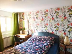 1 dormitorio con cama azul y papel pintado con motivos florales en Precioso apartamento en el centro de Santander, en Santander