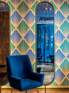 a blue chair in front of a mirror at Hotel Indigo Madrid - Gran Vía by IHG in Madrid