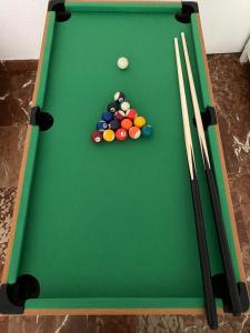 a green pool table with balls and cues on it at Pension El Dorado in Alicante