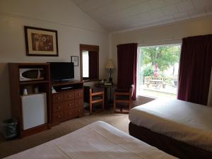 Habitación de hotel con 2 camas y TV en Hickory Grove Motor Inn - Cooperstown en Cooperstown