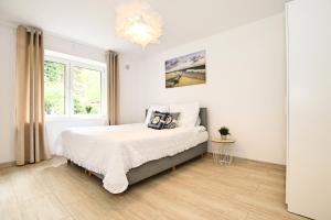 um quarto branco com uma cama e uma janela em Apartamenty Baltic16 em Ustka