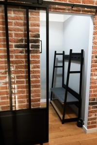 a room with a brick wall and a black ladder at Stilvolles City-Loft mit privatem Whirlpool in Trier