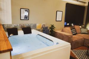 Stilvolles City-Loft mit privatem Whirlpool في ترير: حوض استحمام في غرفة معيشة مع أريكة