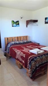 ein Schlafzimmer mit einem Bett mit einer roten Decke darauf in der Unterkunft La Estancia de Runtún Km 7 in Baños