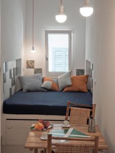 ポリニャーノ・ア・マーレにあるThe Nest / Il Nidoのテーブルとテーブルシックスシックス付きのベッドが備わる小さな客室です。