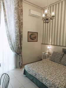 ナポリにあるB&B デイ デクマリのベッドルーム1室(ベッド1台、シャンデリア付)