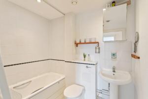 a white bathroom with a sink and a toilet at Breathtaking 2 Bedroom Apartment with Balcony near Stoke Newington in London