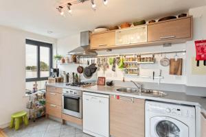 a kitchen with a washer and a dishwasher at Breathtaking 2 Bedroom Apartment with Balcony near Stoke Newington in London