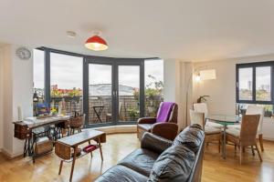 a living room with a couch and a table at Breathtaking 2 Bedroom Apartment with Balcony near Stoke Newington in London