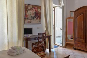 Habitación con cama y escritorio con TV. en Villa Catalano, en Paola