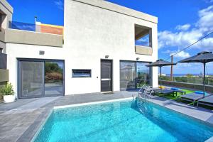a swimming pool in front of a house at Villa Popi - modern villa with private pool by PosarelliVillas in Galatás