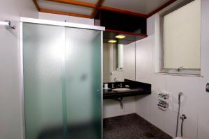 a bathroom with a shower, sink, and toilet at Boulevard Park in Belo Horizonte