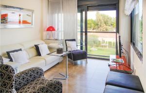 エル・カンページョにあるStunning Apartment In El Campello With 2 Bedrooms, Outdoor Swimming Pool And Swimming Poolのリビングルーム(ソファ、テーブル付)、窓が備わります。