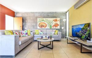 uma sala de estar com um sofá e uma mesa em Gorgeous Home In San Bartolome De Tiraj With Wifi em La Playa de Arguineguín