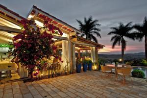 a patio with a table and chairs and flowers at Pousada e Restaurante Caminhos do Bom Café in Jacutinga