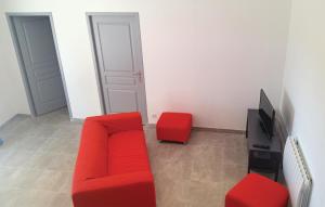 a living room with a red couch and a tv at Amazing Home In Narbonne With Sauna in Narbonne