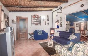 sala de estar con sofá azul y cocina en Villa Antonietta, en Oliena