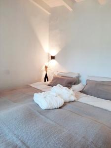 um quarto com 2 camas e toalhas brancas em Casa de Piedras by SIERRA VIVA desing em Cortelazor