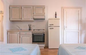 a kitchen with a white refrigerator and a stove at Bilo 4 in Orosei