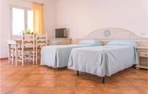 a bedroom with two beds and a table and a dining room at Bilo 4 in Orosei