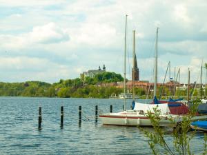a boat is docked at a dock on a lake at Art of Living in Plön