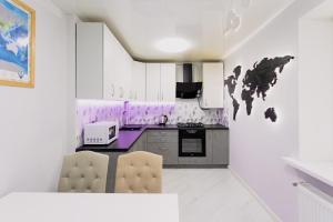 a kitchen with white cabinets and purple accents at Relax Apartments in Sumy