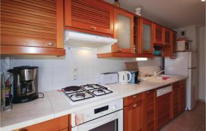 une cuisine avec des armoires en bois et un four à plaques de cuisson dans l'établissement Gorgeous Apartment In Saint Raphael, à Saint-Raphaël
