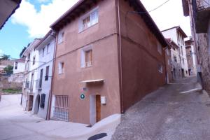 un edificio marrón al lado de una calle en Casa Rural Muro de Aguas - Valdeté, en Muro de Ambas Aguas