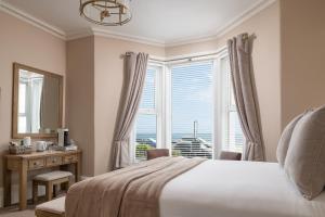 a bedroom with a bed and a window with a view at Pebble House in Llandudno