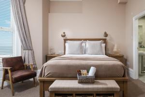 a bedroom with a large bed and a chair at Pebble House in Llandudno