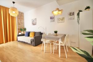 uma sala de estar com uma mesa e um sofá em Mediterranean Way - Tarragona Central Apartments em Tarragona