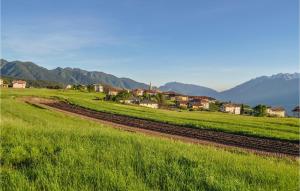a green field with houses and a train track at Lovely Home In Fai Della Paganella in Fai della Paganella