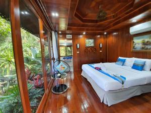 - une chambre avec un lit sur un bateau dans l'établissement บ้านสวนในฝัน-ตลาดน้ำท่าคา, à Samut Songkhram